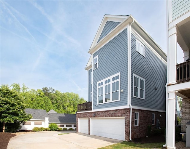 view of home's exterior with an attached garage, brick siding, and concrete driveway