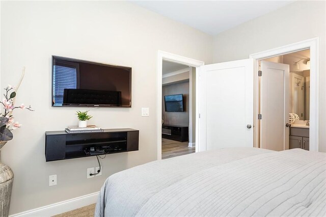 bedroom with baseboards and connected bathroom