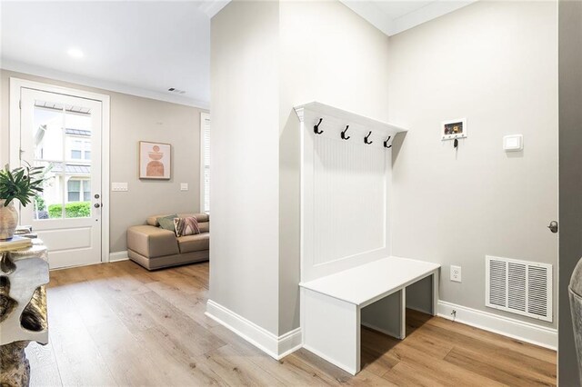 mudroom featuring light wood-style floors, baseboards, and visible vents