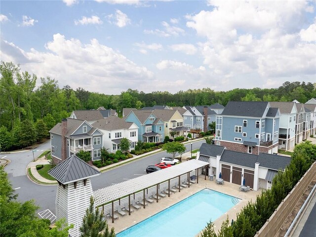 rear view of house featuring a community pool, metal roof, a residential view, and a standing seam roof