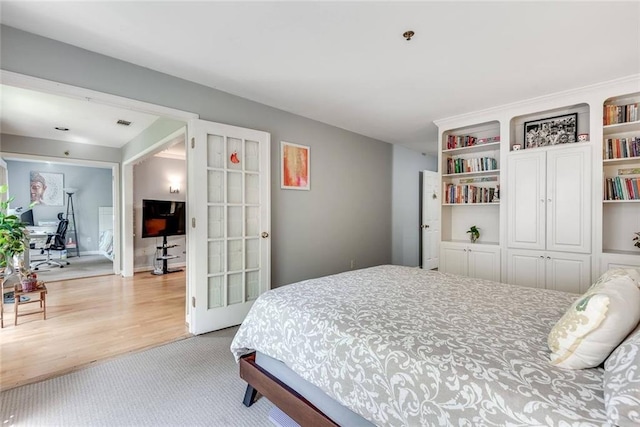 bedroom featuring light wood-style floors, light carpet, and a closet