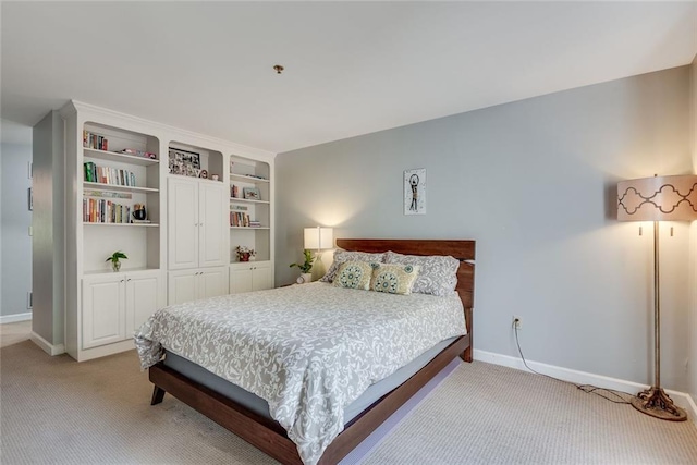 bedroom featuring light colored carpet, baseboards, and a closet