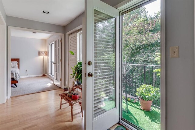 doorway featuring wood finished floors and baseboards