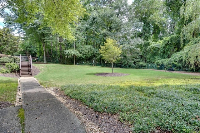 view of grassy yard featuring stairs