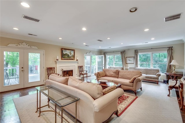 living area with crown molding, recessed lighting, french doors, and a fireplace