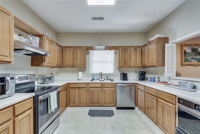 kitchen with appliances with stainless steel finishes, a sink, under cabinet range hood, light countertops, and open shelves