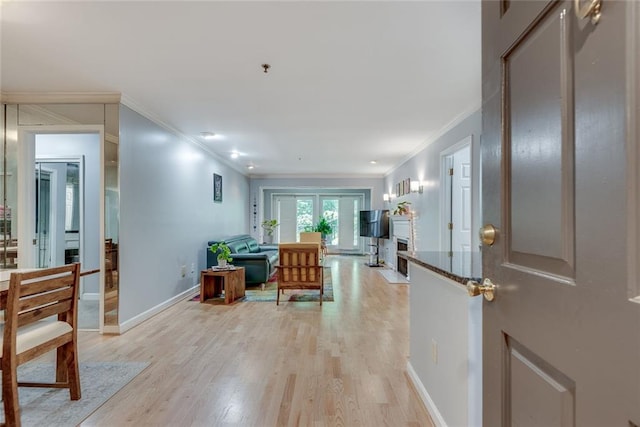 entryway with ornamental molding, light wood-style floors, and baseboards