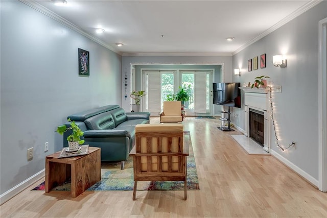 living room with light wood-type flooring, baseboards, a fireplace with flush hearth, and ornamental molding