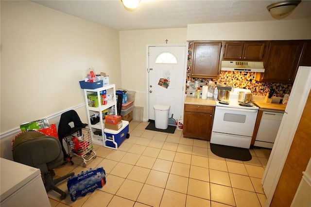 2726 Evans Mill Dr, Lithonia, GA 30058 - kitchen featuring under cabinet range hood, white appliances, light tile patterned flooring, and backsplash