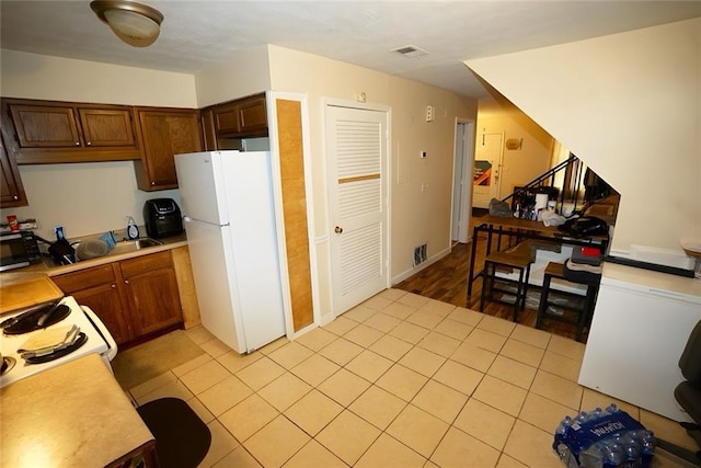 2726 Evans Mill Dr, Lithonia, GA 30058 - kitchen with white appliances, light countertops, and light tile patterned floors