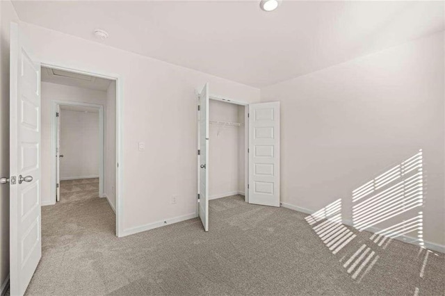 unfurnished bedroom featuring light colored carpet and a closet