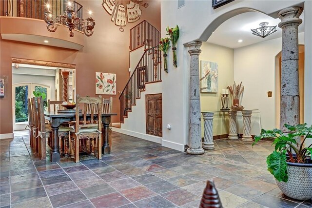 dining area featuring a high ceiling, french doors, and decorative columns