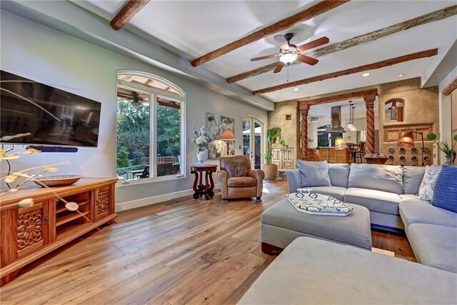 living room with hardwood / wood-style floors, beam ceiling, and ceiling fan