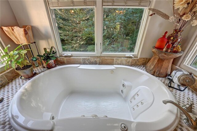 bathroom featuring a tub to relax in and a wealth of natural light