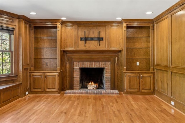 unfurnished living room with light wood finished floors, plenty of natural light, and a fireplace