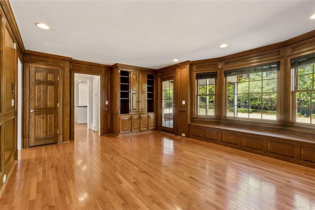 unfurnished living room with recessed lighting, wood walls, and light wood-style floors