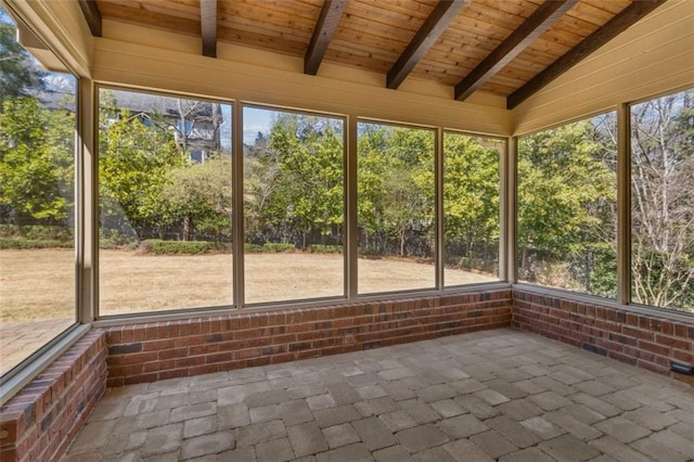 unfurnished sunroom featuring plenty of natural light, wooden ceiling, and vaulted ceiling with beams