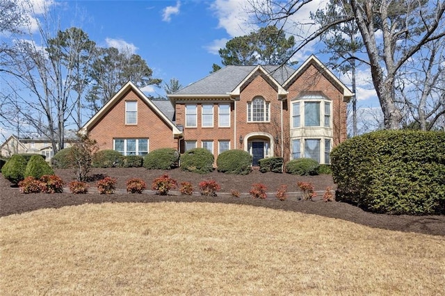 view of front of home with brick siding and a front yard