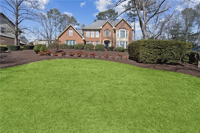 view of front of house with a front lawn and brick siding