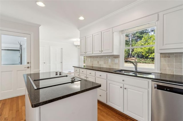 kitchen with a kitchen island, dishwasher, ornamental molding, black electric cooktop, and a sink