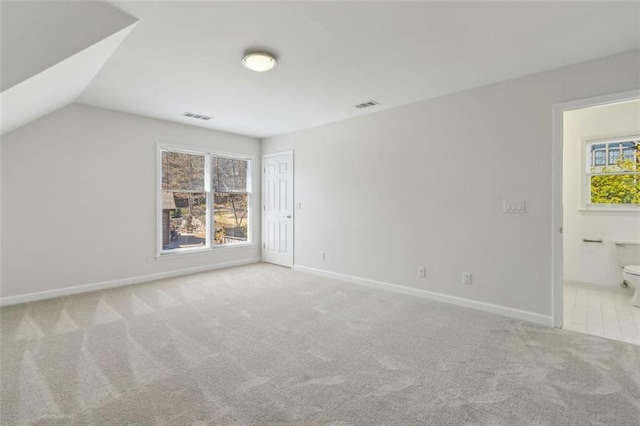 interior space with visible vents, baseboards, carpet flooring, and vaulted ceiling