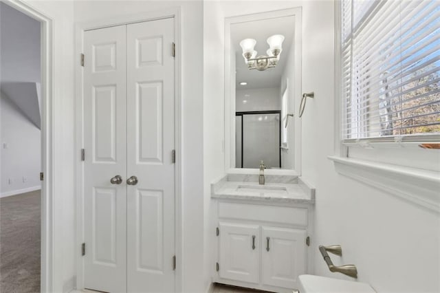 full bath with a closet, vanity, an inviting chandelier, and a shower stall