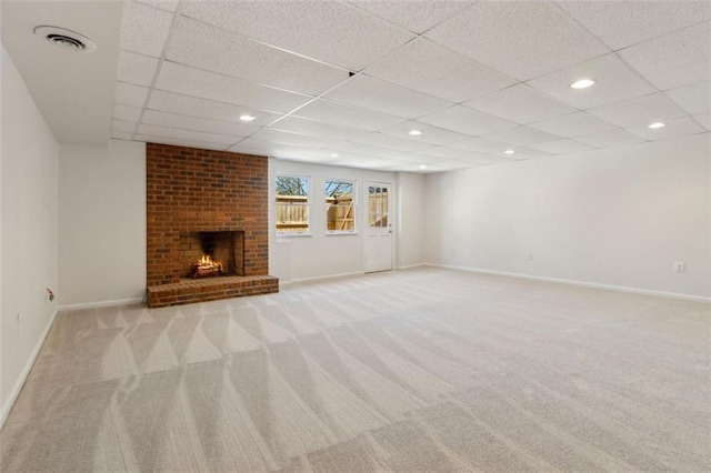 unfurnished living room featuring visible vents, light carpet, baseboards, and a fireplace