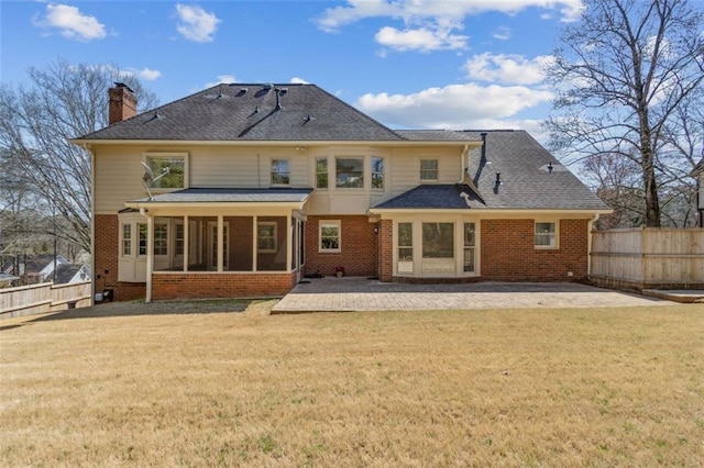 rear view of house with a patio, fence, a yard, and a sunroom