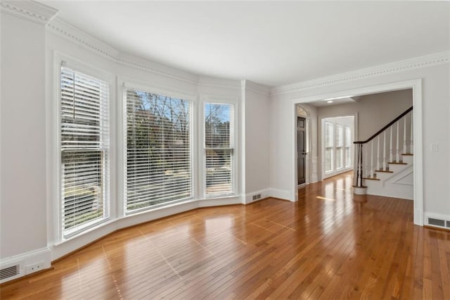 spare room featuring stairs, baseboards, visible vents, and light wood finished floors