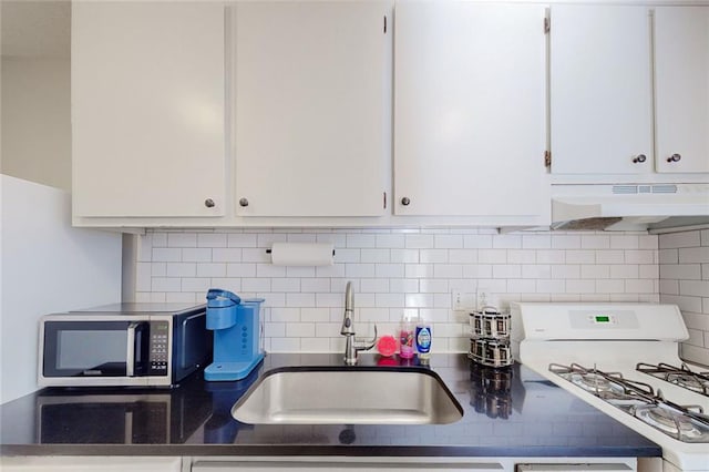 kitchen featuring white cabinetry, sink, white gas stove, and decorative backsplash