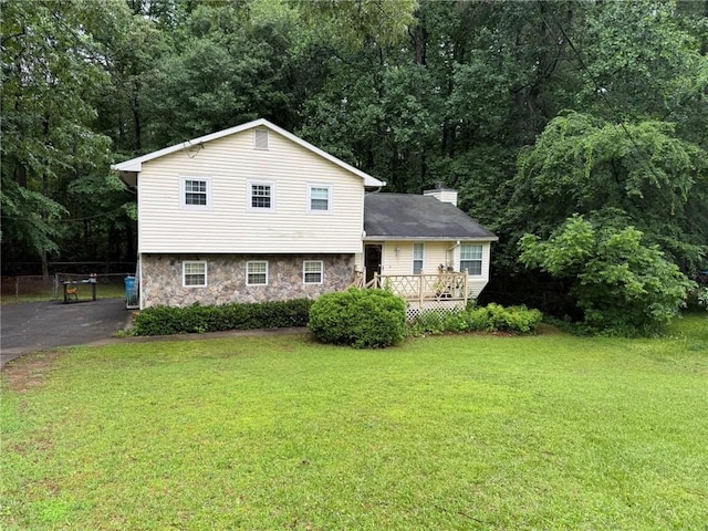 2523 Bronco Trl, Duluth, GA 30096 - view of front facade with stone siding, driveway, a chimney, and a deck
