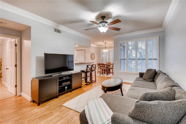 living room with ornamental molding, ceiling fan, and light hardwood / wood-style flooring