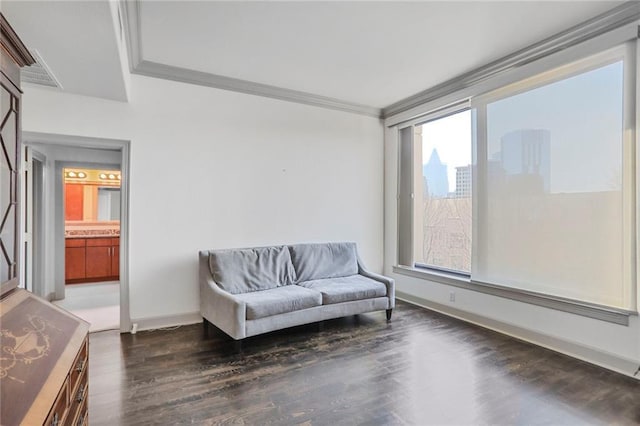 sitting room featuring visible vents, baseboards, wood finished floors, and crown molding