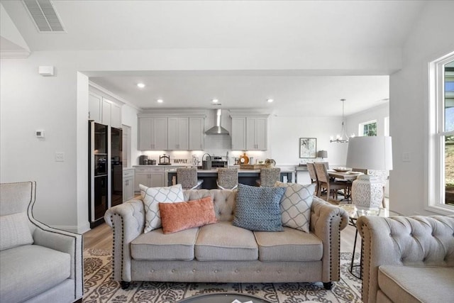 living room featuring light hardwood / wood-style flooring, sink, and a chandelier