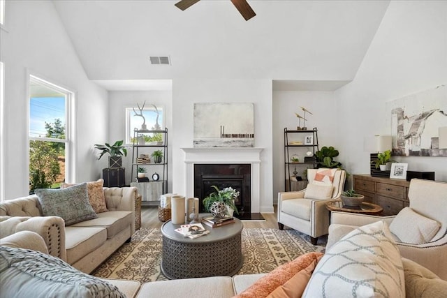 living room with high vaulted ceiling, hardwood / wood-style flooring, and ceiling fan