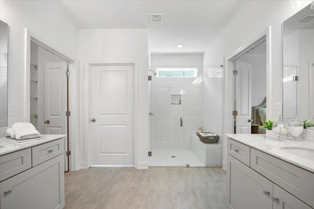 bathroom with vanity and a shower with door