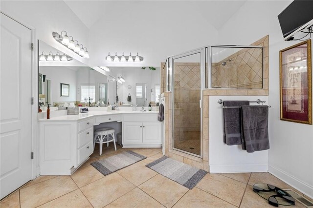 full bathroom with vaulted ceiling, a shower stall, tile patterned flooring, and vanity