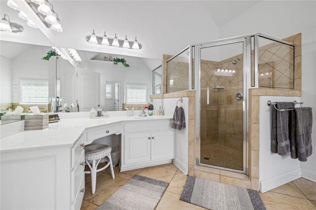 bathroom featuring vaulted ceiling, a shower stall, tile patterned floors, and vanity