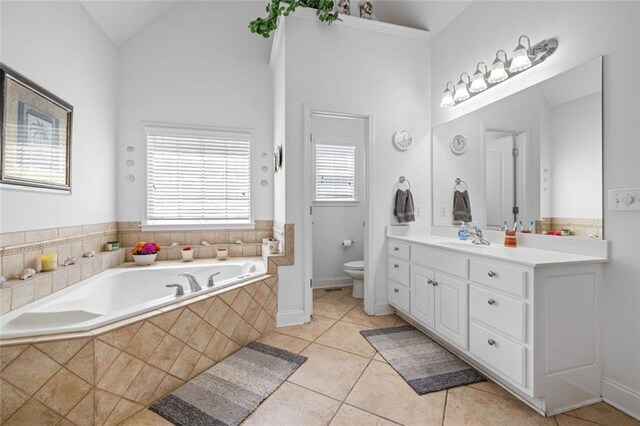 full bath featuring toilet, a garden tub, vanity, tile patterned floors, and lofted ceiling