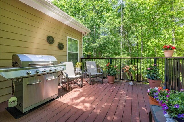 wooden deck featuring a grill