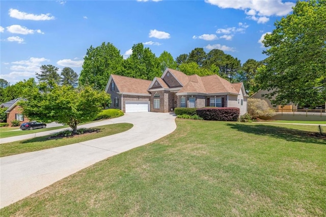 view of front of home featuring an attached garage, driveway, and a front yard