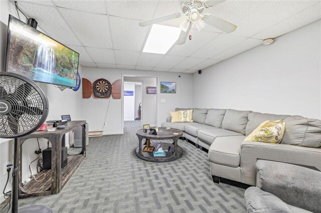 living area with carpet, a drop ceiling, ceiling fan, and baseboards