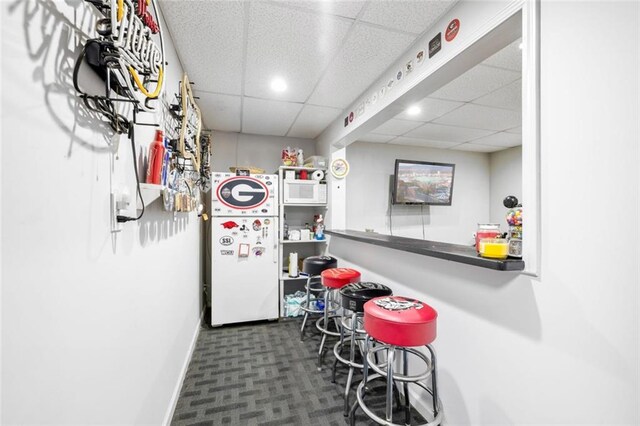 bar area featuring a drop ceiling, white appliances, baseboards, recessed lighting, and carpet flooring
