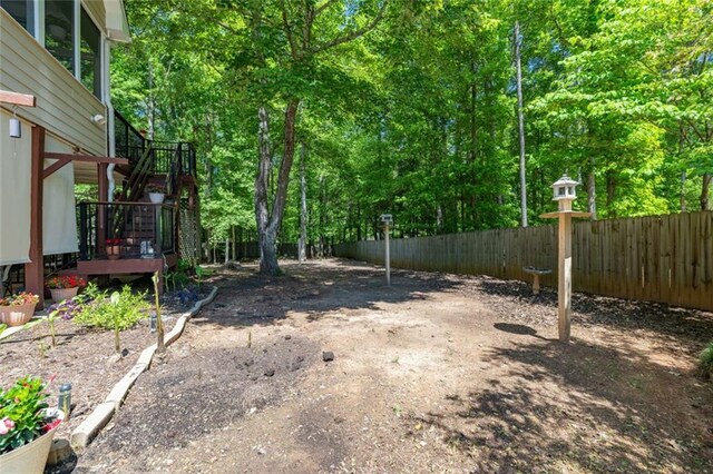 view of yard with fence, stairs, and a wooden deck