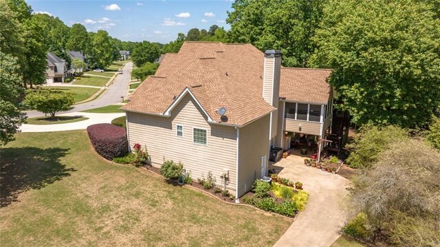 view of home's exterior featuring a chimney and a yard