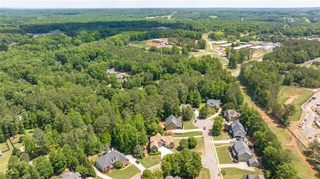 aerial view of property's location with a heavily wooded area and nearby suburban area