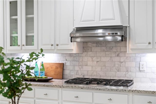 130 Robin Rd, Marietta, GA 30067 - kitchen featuring wall chimney exhaust hood, white cabinets, glass insert cabinets, and decorative backsplash