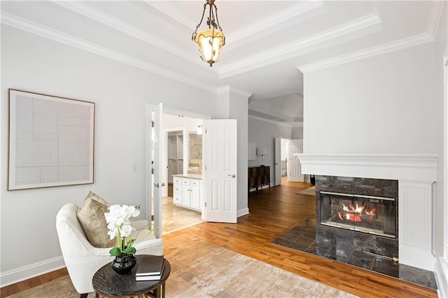 130 Robin Rd, Marietta, GA 30067 - living area with crown molding, wood finished floors, a raised ceiling, a tiled fireplace, and baseboards