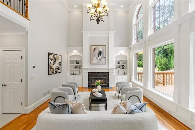 130 Robin Rd, Marietta, GA 30067 - living room with a high ceiling, light wood finished floors, crown molding, a chandelier, and a premium fireplace