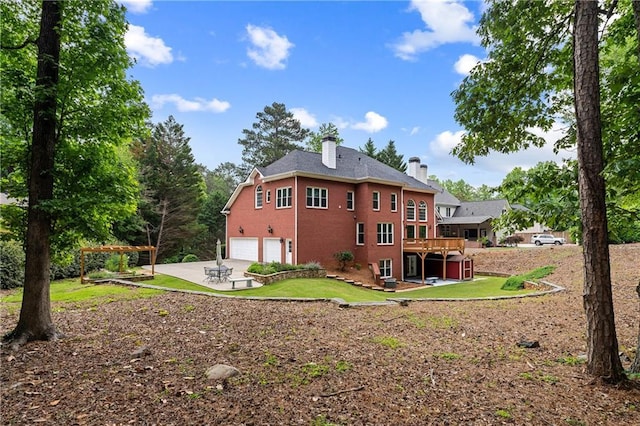 130 Robin Rd, Marietta, GA 30067 - back of house featuring a chimney, a garage, driveway, a wooden deck, and a lawn